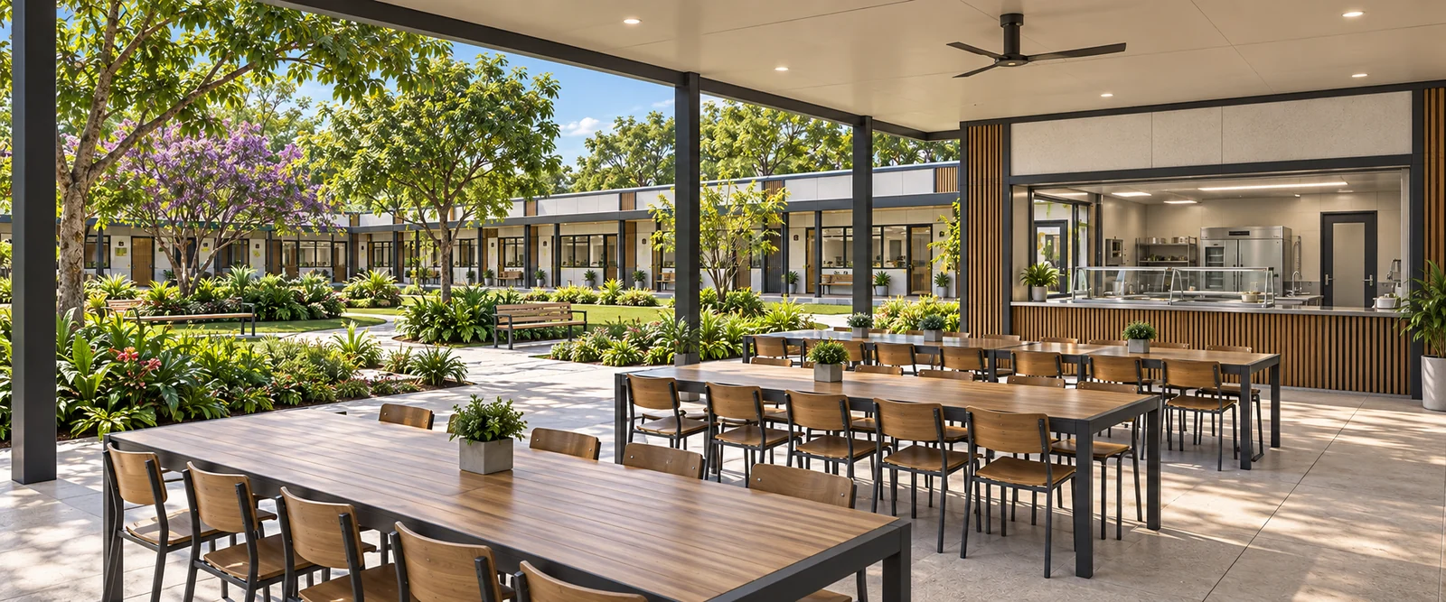 Refeitório aberto da Escola Modular integrado ao pátio arborizado, com balcão de distribuição.